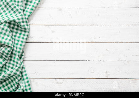 Green checkered kitchen tablecloth on wooden table. Stock Photo