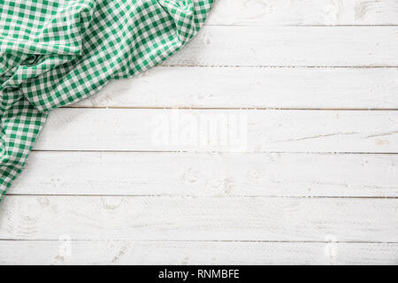 Green checkered kitchen tablecloth on wooden table. Stock Photo