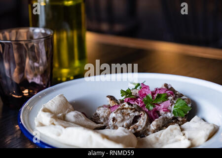 Egg-plant salad with pita served in a restaurant. Close-up view of vegan aubergine dish, shot in natural light Stock Photo