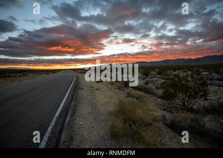 Dramatic sunset over desert landscape, country road, sunset, Mojave desert, Mojave National Preserve, California, USA Stock Photo