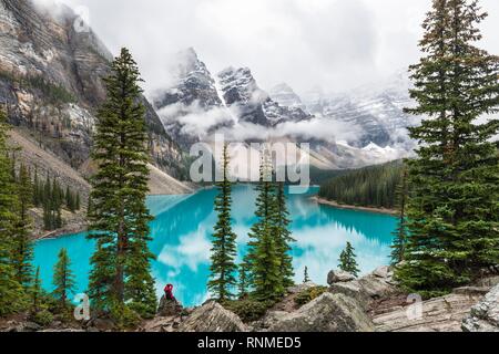 Clouds hanging between the mountain peaks, reflection in turquoise glacial lake, Moraine Lake, Valley of the Ten Peaks, Rocky Mountains, Banff Nationa Stock Photo