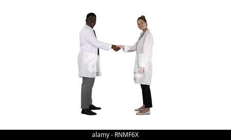 Doctors shaking hands and posing to camera on white background. Stock Photo