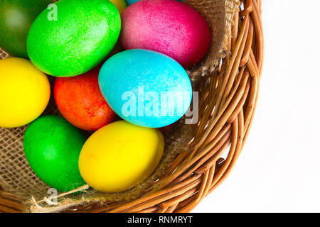 Brightly colored closeup easter eggs in basket, holiday background Stock Photo