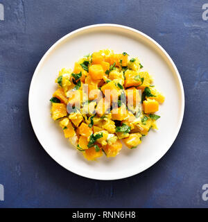 Stir-fried pumpkin with eggs on plate over blue stone background. Pumpkin and egg stir fry in thai style. Top view, flat lay Stock Photo