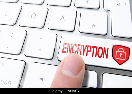 finger pressing key on computer keyboard labeled ENCRYPTION with padlock on shield Stock Photo
