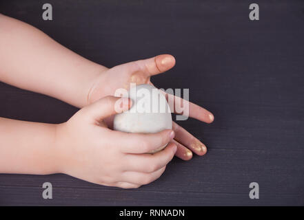 Close up of child holding Easter eggs in a hand Stock Photo