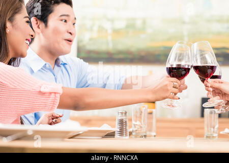 Couple toasting wineglasses with friends Stock Photo