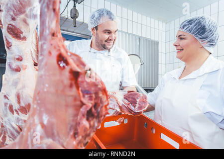 Team of butchers working with meat in butchery Stock Photo