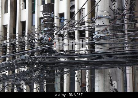 City cable chaos in Asia - tangled mess of cables in Manila, Philippines. Stock Photo