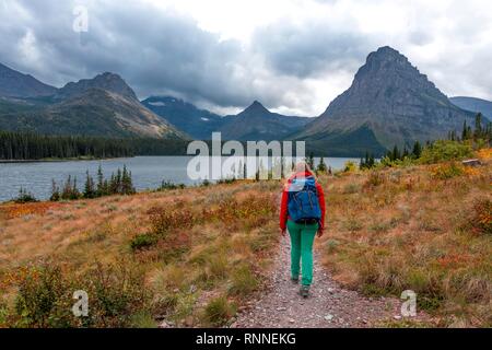 Woman walking on a hiking trail, Two Medicine Lake, Glacier National Park, Montana, USA Stock Photo