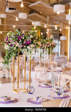 Volume magnificent composition from flowers at a wedding. Wedding floristics against the background of the hall Stock Photo