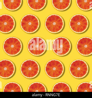 Red orange slices pattern on yellow color background. Minimal flat lay top view food texture Stock Photo