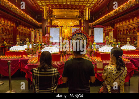 Buddhist Worshipers Praying upon Entering Main Prayer Hall, Buddha Tooth Relic Temple, Singapore. Stock Photo