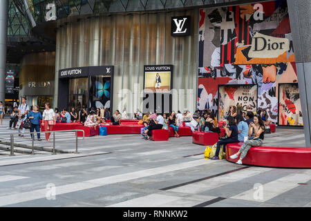 People Relaxing outside the ION Mall, Orchard Road, Singapore. Stock Photo