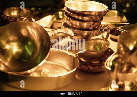 Heavy silver bowls and sauce bowls stacked in golden light. Stock Photo