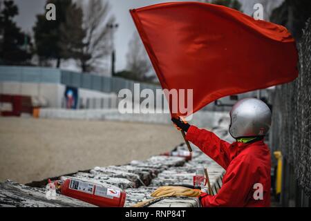 Barcelona, Spain. 20th Feb, 2019. A marshal waves a red flag during day three of the Formula One winter testing at Circuit de Catalunya Credit: Matthias Oesterle/Alamy Live News Stock Photo