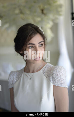 A young pensive couple have a traditional English White Wedding, they are both dark haired and good looking but seem unhappy Stock Photo
