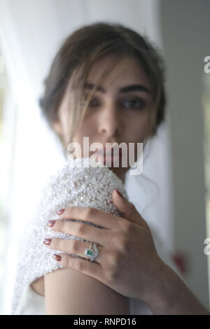 A young pensive couple have a traditional English White Wedding, they are both dark haired and good looking but seem unhappy Stock Photo