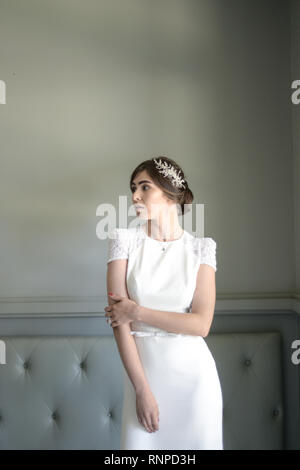 A young pensive couple have a traditional English White Wedding, they are both dark haired and good looking but seem unhappy Stock Photo