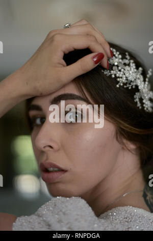 A young pensive couple have a traditional English White Wedding, they are both dark haired and good looking but seem unhappy Stock Photo