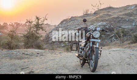 Packed old motorcycle standing in the desert in the sunrise Stock Photo