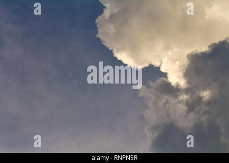 Dark clouds with orange sunset light on sky Stock Photo