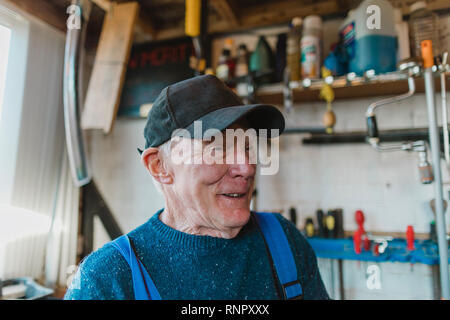 Close up headshot of a senior man in his workshop. Stock Photo