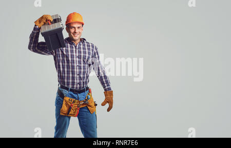 Male builder in  helmet in a plaid shirt smiling Stock Photo