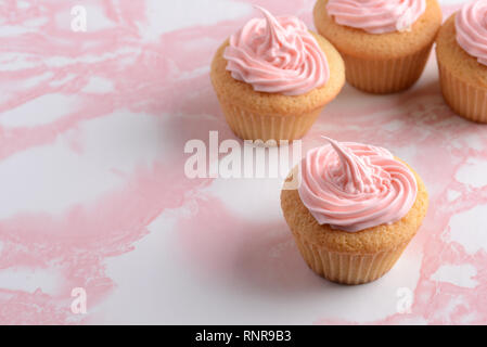 Closeup cupcake with pink frosting on marble table Stock Photo