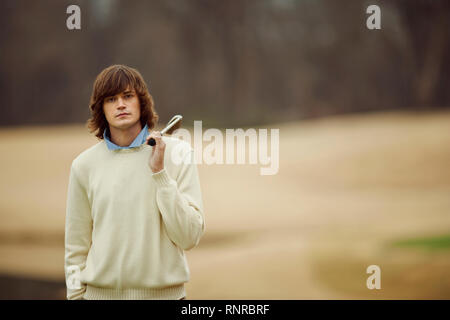 Young man carrying golf club over shoulder. Stock Photo