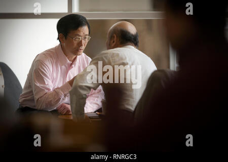 Mid-adult man sitting with a senior adult man at a table. Stock Photo