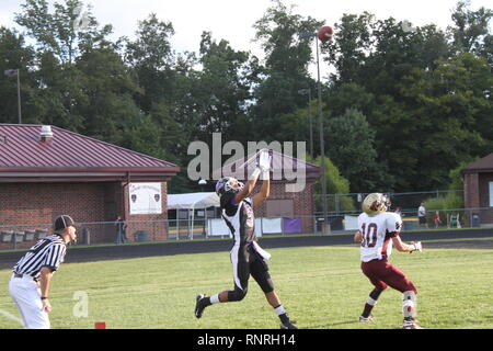 American high school football player in Virginia secures a long pass and touches one foot down in the end zone as a referee signals touchdown. Stock Photo