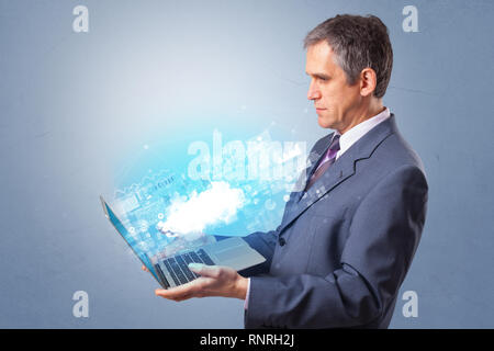 Man holding laptop projecting notifications, symbols and information based on cloud technology system  Stock Photo