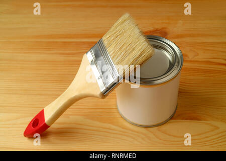 Paintbrush on a Paint can isolated on wooden background Stock Photo