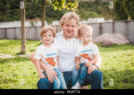 Happy father with two little sons in park Stock Photo