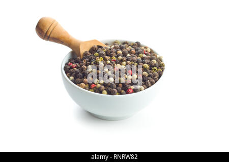 Different types of dried peppercorn in bowl isolated on white background. Stock Photo