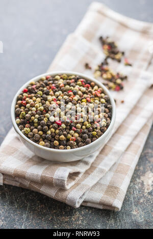 Different types of dried peppercorn in bowl. Stock Photo
