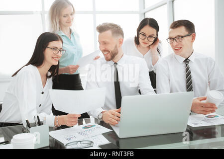 group of self-confident businessmen analyzing data using a laptop Stock Photo