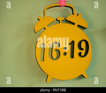 wooden plate sign made in shape of vintage alarm clock with current time Stock Photo