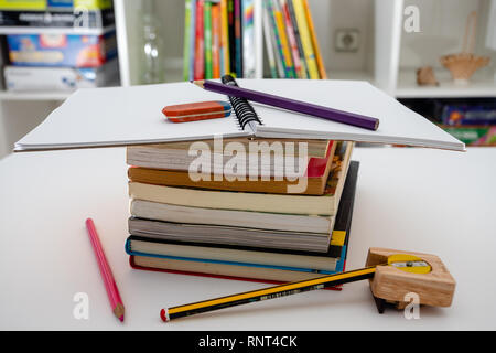Stack of books and stationery on white background. Doing homework Stock Photo