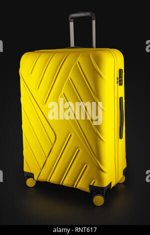 Yellow suitcase with luggage for flight isolated on black background, clipping path Stock Photo