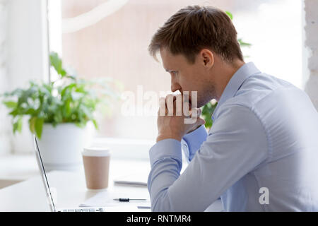 Focused businessman sitting in office working and thinking  Stock Photo