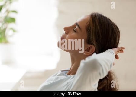 Female with closed eyes putting hands behind head resting Stock Photo