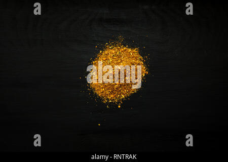 Close-up image of curry powder on black wood background, view above Stock Photo