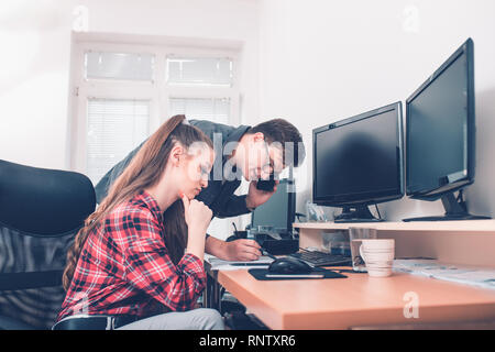 Portrait of two young colleagues making final decisions discussing working plans and documentation in office - Image Stock Photo