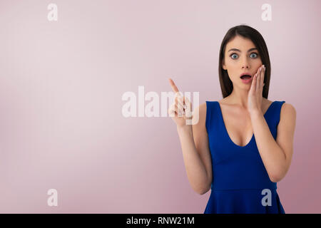 Surprised girl indicates a blank space for your text Stock Photo