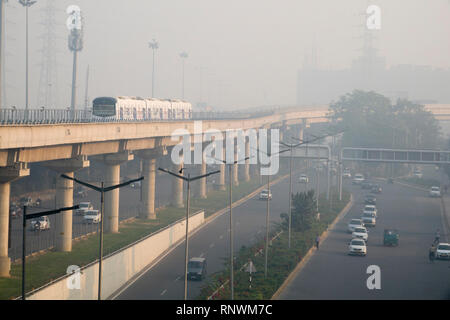 Metro train and traffic in hazardous levels of air pollution in Cyber City, Gurugram, India