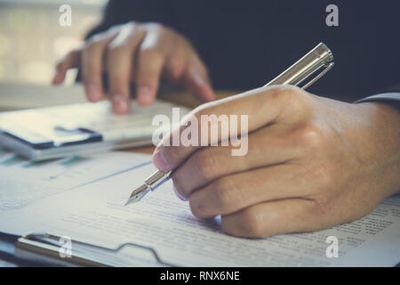 Business man signing a contract. Owns the business sign personally, director of the company, solicitor. Real estate agent holding house, financial or  Stock Photo