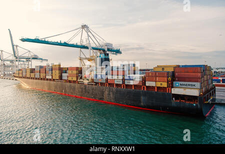 Miami, USA - March, 18, 2016: ship with cargo containers and crane in sea port. Maritime container port, dock or terminal. Shipping, freight, logistics. Water transport vessel transportation