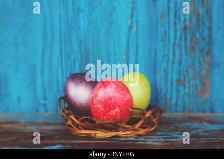 Easter colorful painted eggs in the nest on rustic wooden background. Easter concept. Traditional decorations for the feast of the resurrection Stock Photo